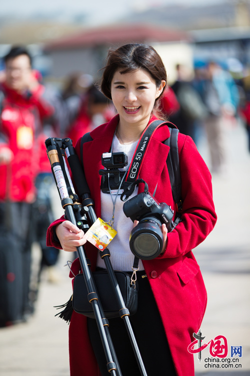 2016年兩會，人民大會大堂前，一位笑容燦爛的紅衣女記者正步入大會堂。中國網(wǎng) 鄭亮 攝