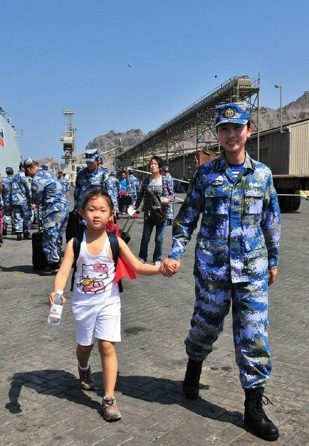 2015年3月，也門，海軍女戰士牽著一名小女孩的手準備登上軍艦。