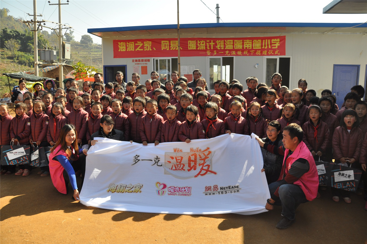 2014年11月20日，“多一克溫暖”公益團隊來到8.3大地震的重災區——云南省昭通市魯甸縣的南筐小學。越過崎嶇山路，將一批又一批暖心羽絨服送到了師生們的手中，也將社會的關懷和愛意傳遞給了這些可愛的人。