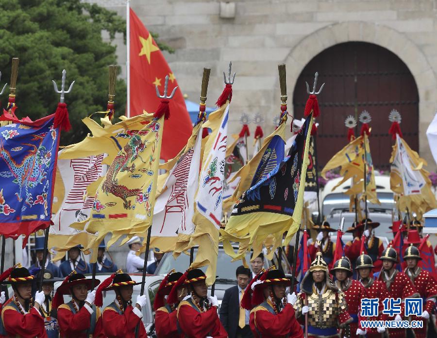 7月3日，韓國總統(tǒng)樸槿惠在青瓦臺總統(tǒng)府舉行隆重儀式，歡迎中國國家主席習(xí)近平對韓國進行國事訪問。這是習(xí)近平的車隊在身著民族服裝的韓國禮儀隊伍引導(dǎo)下駛?cè)肭嗤吲_。新華社記者丁林攝  